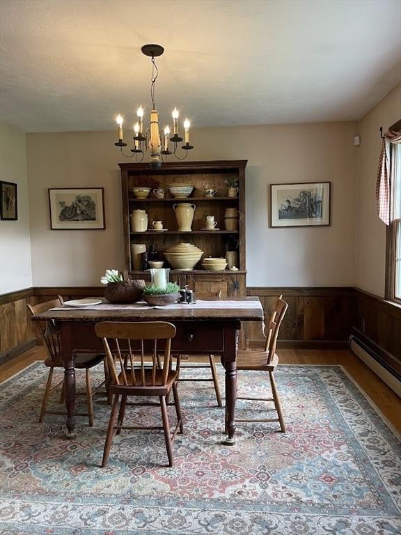 33 Whittemore St, Leicester, MA 01524 - dining room featuring wood finished floors, a chandelier, a wainscoted wall, and wood walls