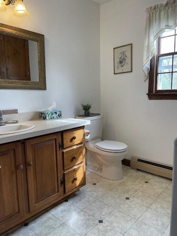 33 Whittemore St, Leicester, MA 01524 - half bathroom featuring a baseboard heating unit, vanity, toilet, and tile patterned floors