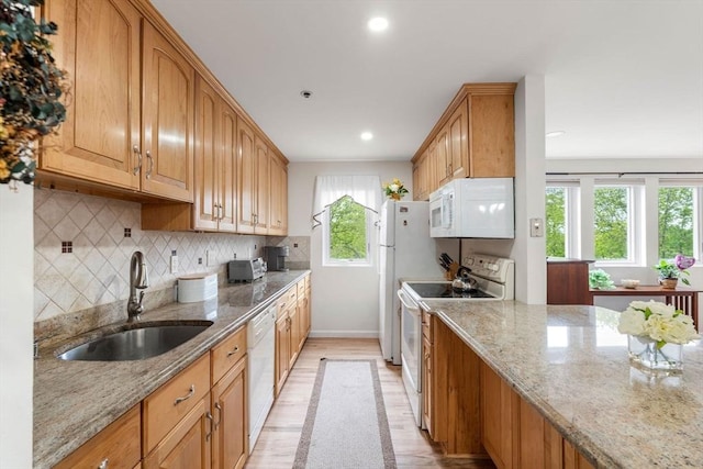 36 Dunham Rd Unit 109, Beverly, MA 01915 - kitchen with white appliances, a sink, light wood-type flooring, baseboards, and light stone counters