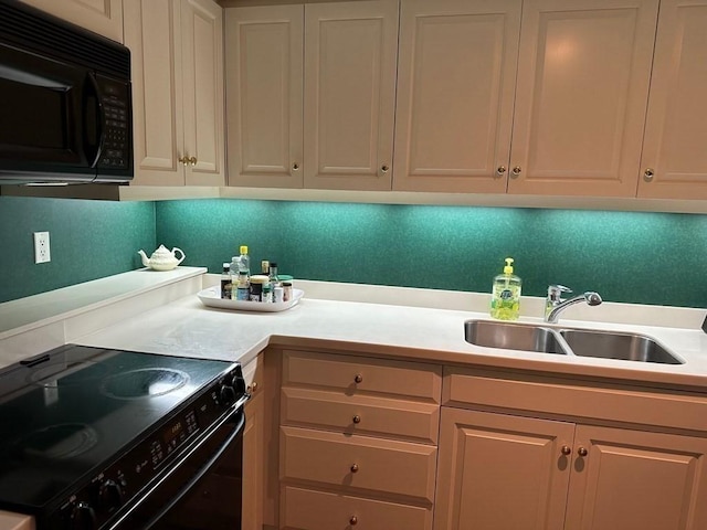 kitchen featuring black appliances, a sink, and light countertops