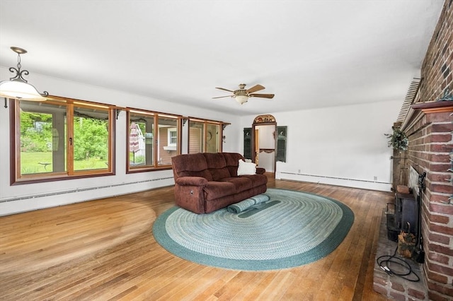 148 Walnut Hill Rd, Orange, MA 01364 - living area featuring hardwood / wood-style flooring, baseboard heating, a fireplace, and a ceiling fan