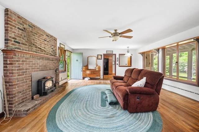 148 Walnut Hill Rd, Orange, MA 01364 - living area with wood finished floors, a wood stove, ceiling fan, and baseboard heating