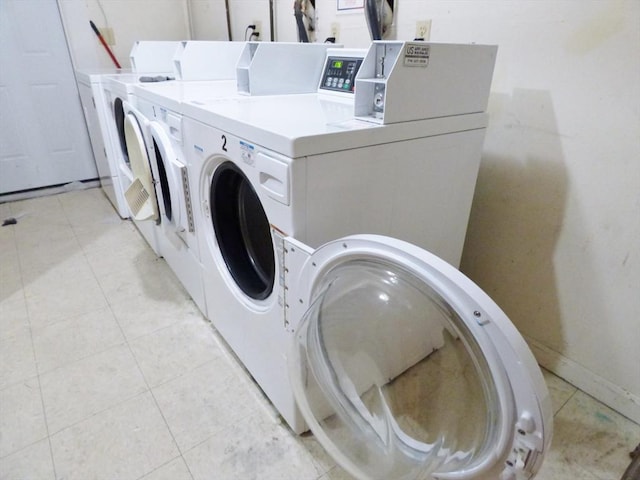 washroom with washing machine and dryer and light tile patterned flooring