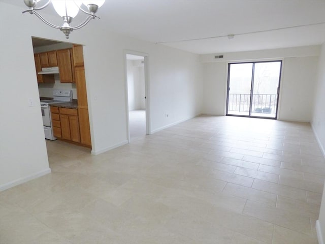 unfurnished room featuring an inviting chandelier