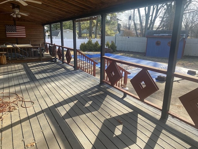 wooden terrace featuring ceiling fan and a storage unit