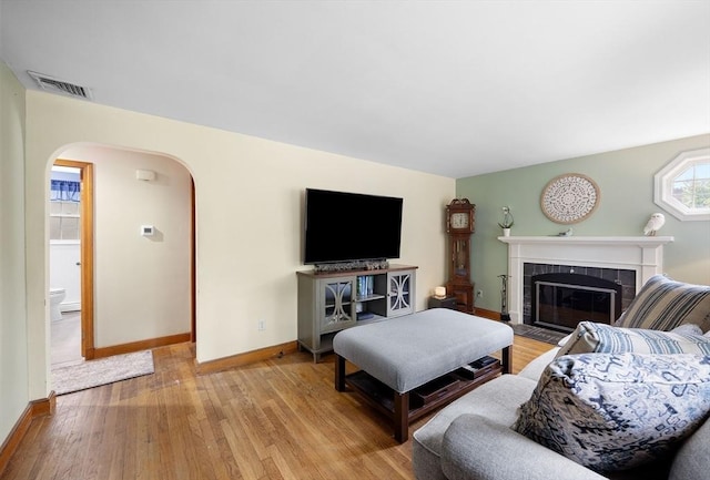 83 Summit Rd, Abington, MA 02351 - living area featuring light wood finished floors, arched walkways, baseboards, and a fireplace