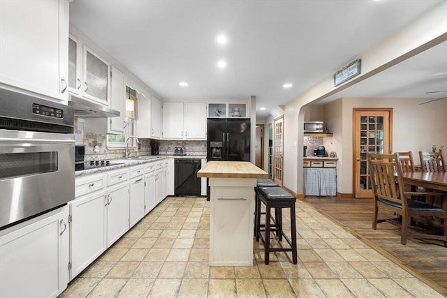 83 Summit Rd, Abington, MA 02351 - kitchen with black appliances, wooden counters, tasteful backsplash, a sink, and a breakfast bar
