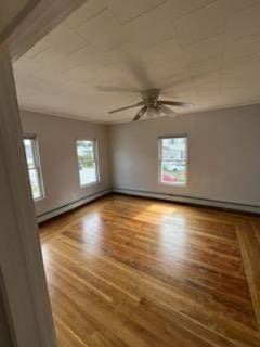10 Stevens St, Lawrence, MA 01843 - empty room featuring baseboard heating, wood finished floors, and a ceiling fan