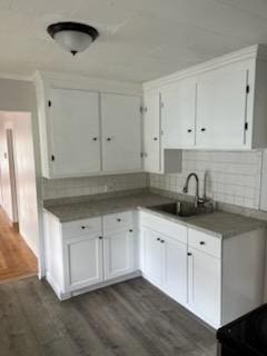10 Stevens St, Lawrence, MA 01843 - kitchen with dark wood-style floors, white cabinets, a sink, backsplash, and ornamental molding