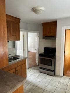 10 Stevens St, Lawrence, MA 01843 - kitchen with stainless steel electric range oven, light tile patterned floors, ventilation hood, and a sink
