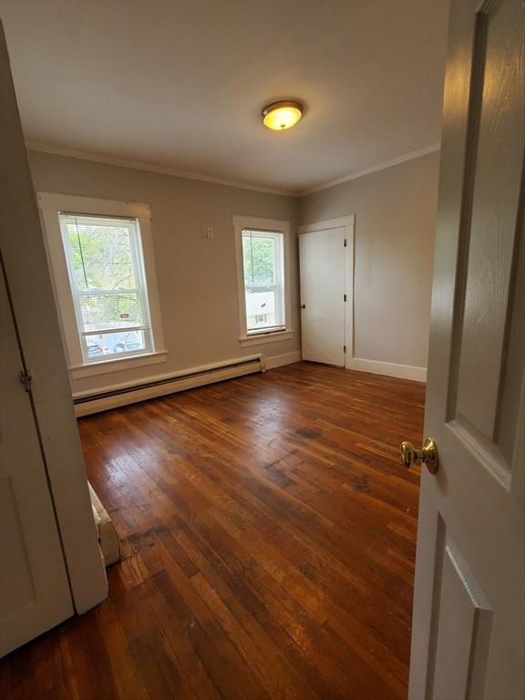 10 Stevens St, Lawrence, MA 01843 - unfurnished room featuring a baseboard heating unit, crown molding, hardwood / wood-style flooring, and baseboards