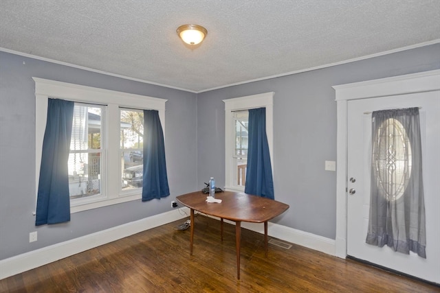 entryway with hardwood / wood-style flooring, ornamental molding, and a textured ceiling