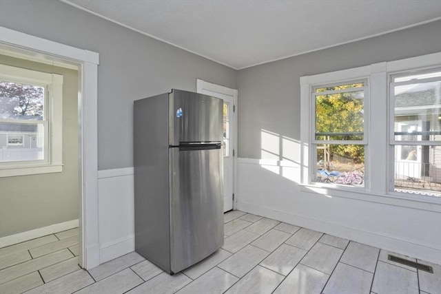 kitchen featuring freestanding refrigerator and baseboards