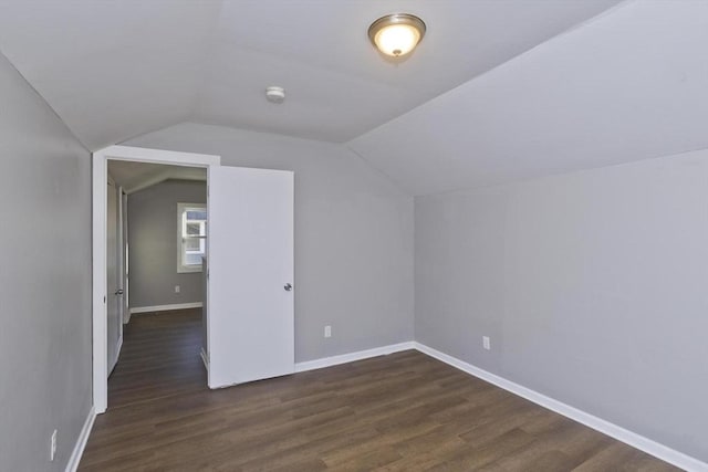 bonus room featuring dark wood-style floors, vaulted ceiling, and baseboards