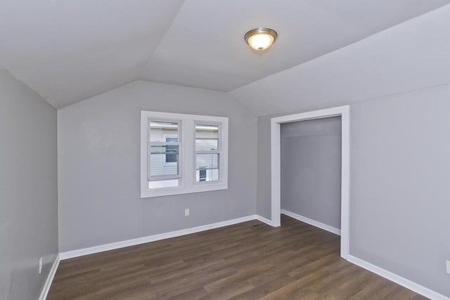 bonus room with dark wood finished floors, baseboards, and lofted ceiling