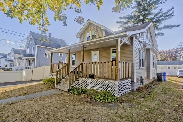 bungalow-style home with a porch and fence
