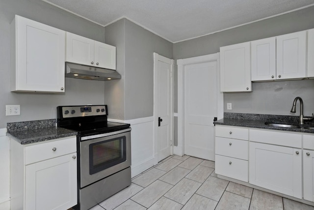 kitchen with dark stone counters, sink, white cabinetry, a textured ceiling, and stainless steel electric range oven