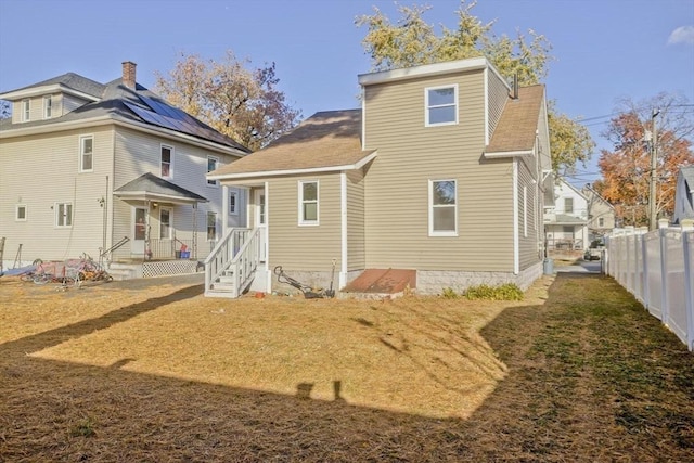 rear view of house featuring a shingled roof and a chimney