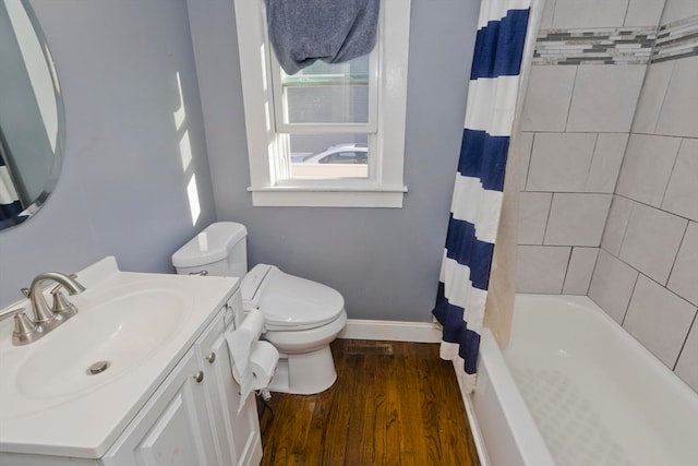 full bathroom featuring vanity, hardwood / wood-style floors, shower / bath combo with shower curtain, and toilet