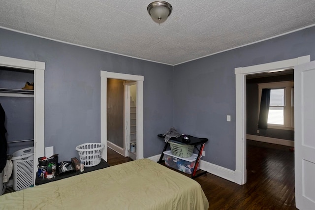 bedroom featuring dark wood-type flooring and crown molding