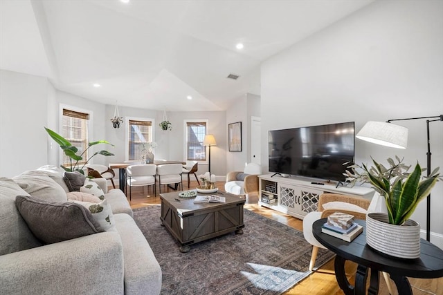 living room featuring vaulted ceiling and hardwood / wood-style floors