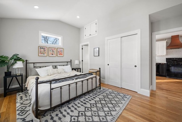 bedroom featuring a closet, vaulted ceiling, and light hardwood / wood-style flooring