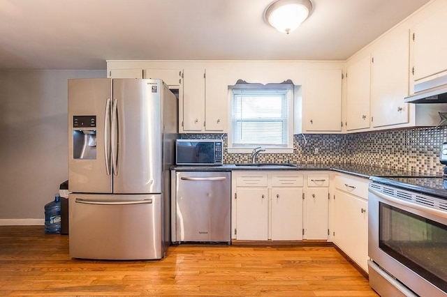 3 Sears Ave, Webster, MA 01570 - kitchen featuring stainless steel appliances, white cabinets, dark countertops, tasteful backsplash, and light wood-type flooring