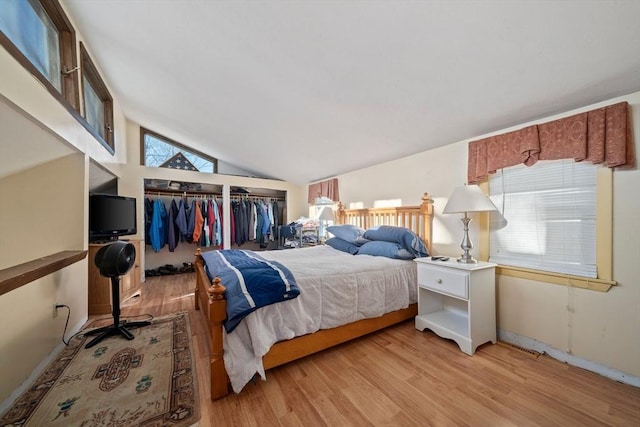 bedroom featuring light wood-style floors and lofted ceiling