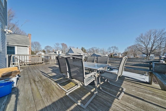 wooden deck with a residential view and outdoor dining area