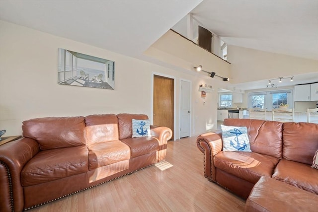 living area with high vaulted ceiling and light wood-style floors