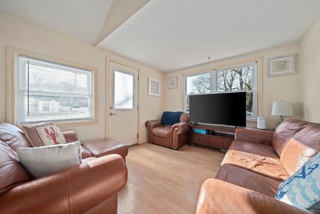 living area with vaulted ceiling and light wood-style flooring