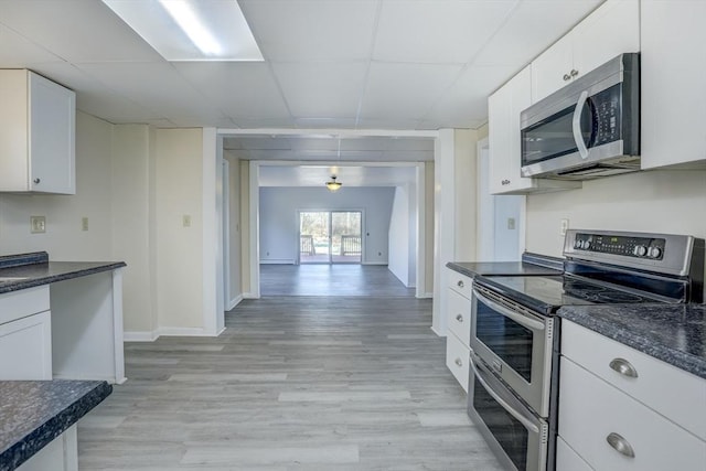 kitchen featuring white cabinetry, a drop ceiling, light hardwood / wood-style floors, and appliances with stainless steel finishes