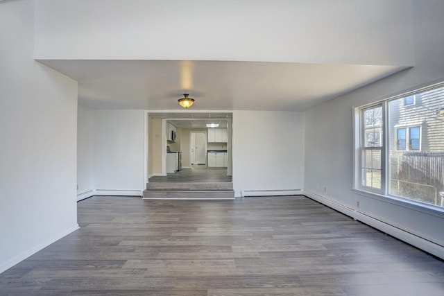 unfurnished living room featuring wood-type flooring and baseboard heating