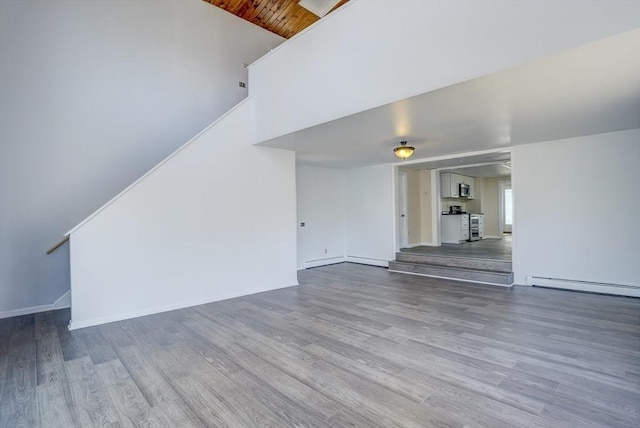 unfurnished living room with wood-type flooring, wood ceiling, and a baseboard radiator