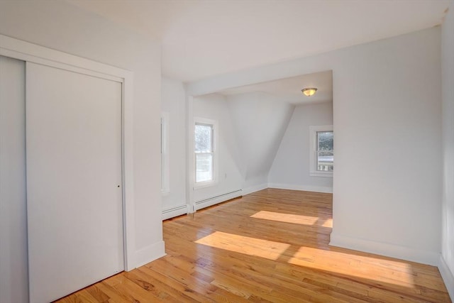 bonus room featuring hardwood / wood-style floors and a baseboard heating unit