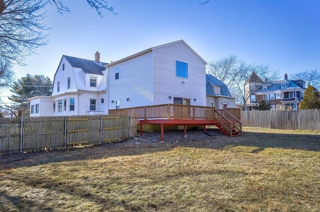 rear view of house with a yard and a wooden deck