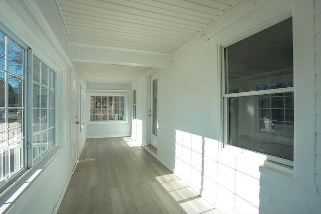 corridor featuring hardwood / wood-style flooring and beamed ceiling