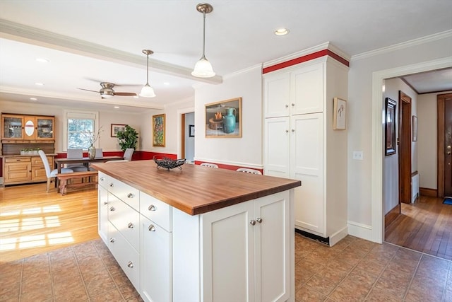 kitchen with crown molding, wood counters, white cabinets, and recessed lighting