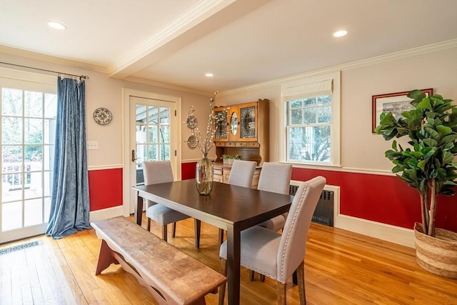 dining area featuring ornamental molding, light wood finished floors, and a healthy amount of sunlight