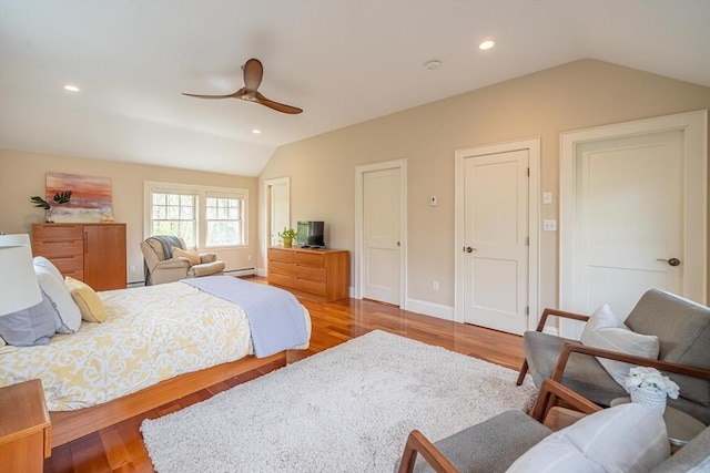bedroom with recessed lighting, a baseboard heating unit, wood finished floors, and lofted ceiling