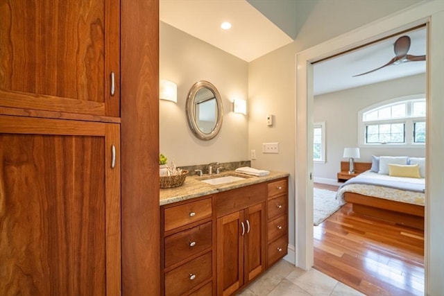 bathroom featuring a ceiling fan, wood finished floors, ensuite bathroom, and vanity