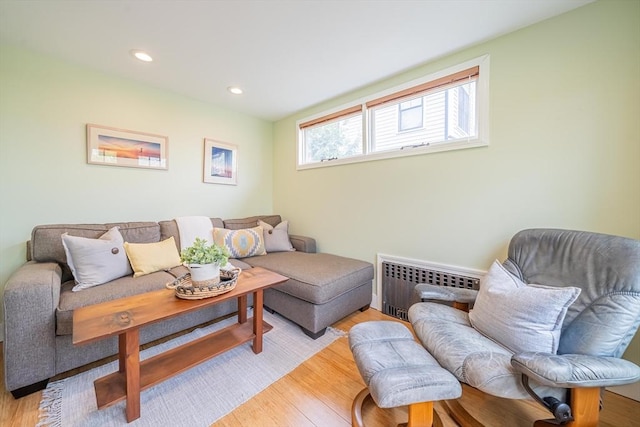living area featuring light wood-style floors, recessed lighting, and radiator