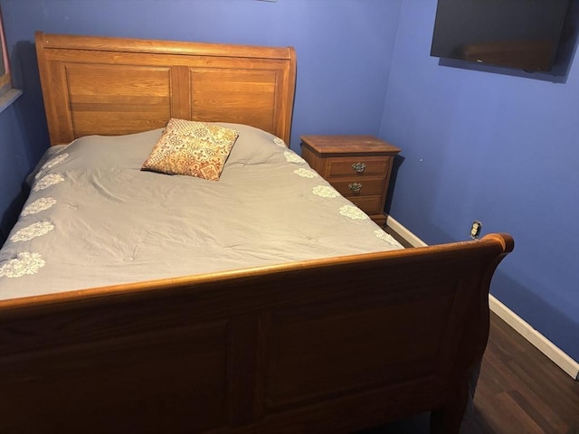 bedroom with dark wood-type flooring