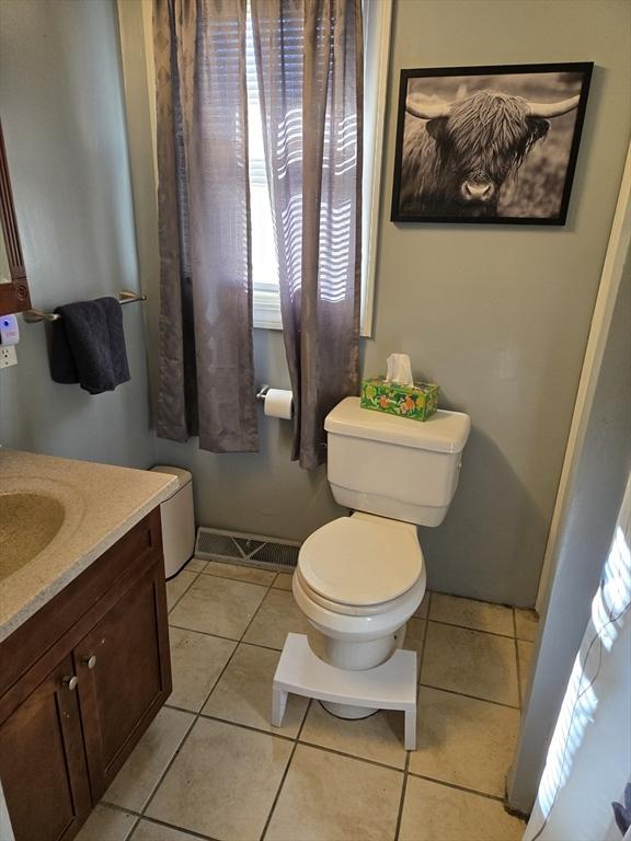 bathroom with vanity, tile patterned floors, and toilet