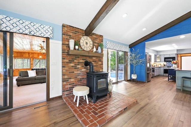 living area featuring a wood stove, plenty of natural light, hardwood / wood-style flooring, baseboards, and recessed lighting