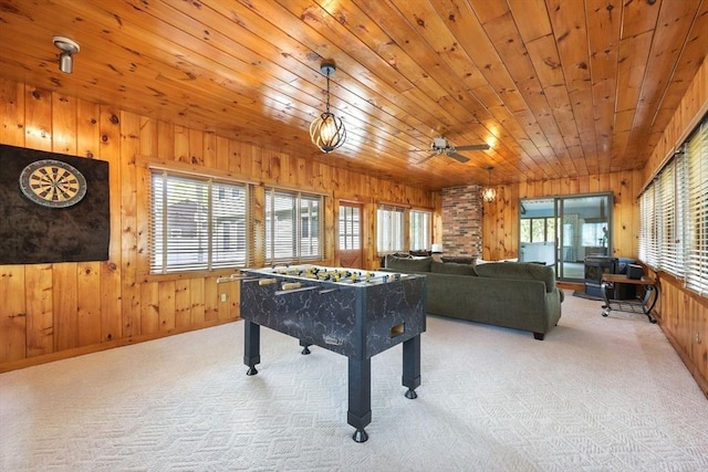 rec room with wooden walls, carpet flooring, wooden ceiling, and a ceiling fan