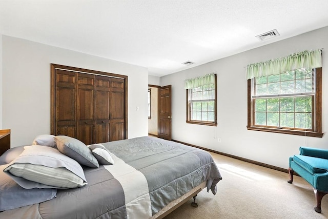bedroom featuring light carpet, a closet, and baseboards