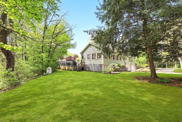 view of grassy yard with a wooden deck