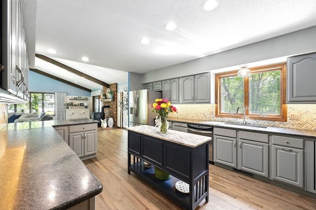 kitchen with gray cabinets, a sink, stainless steel appliances, backsplash, and recessed lighting