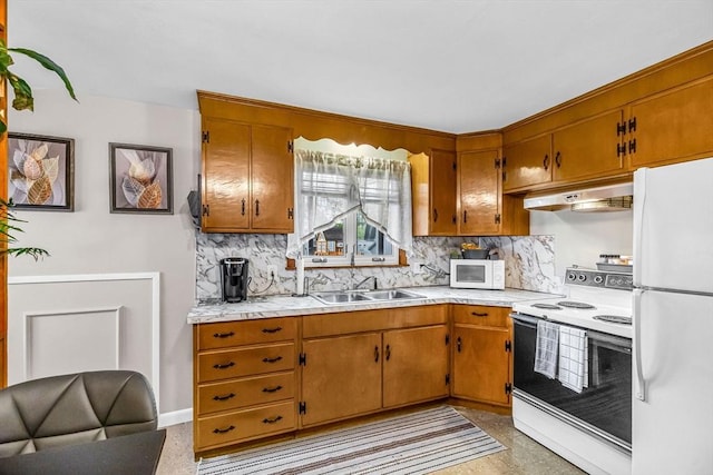 kitchen with white appliances, under cabinet range hood, a sink, backsplash, and light countertops